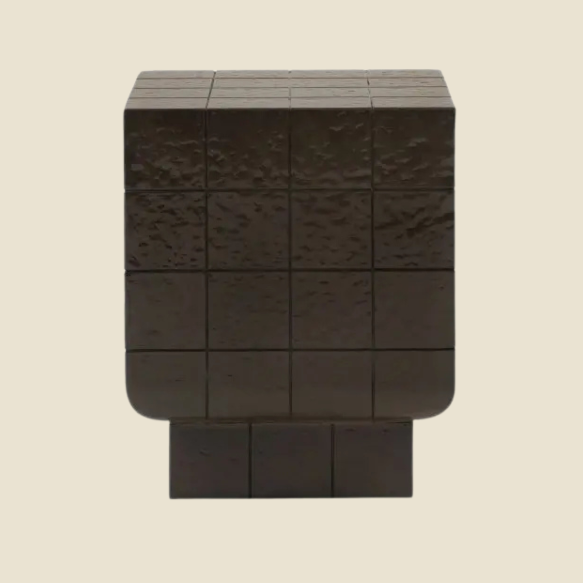A dark brown textured cube side table with a grid pattern and a tiered base, shown against a solid light beige background.
