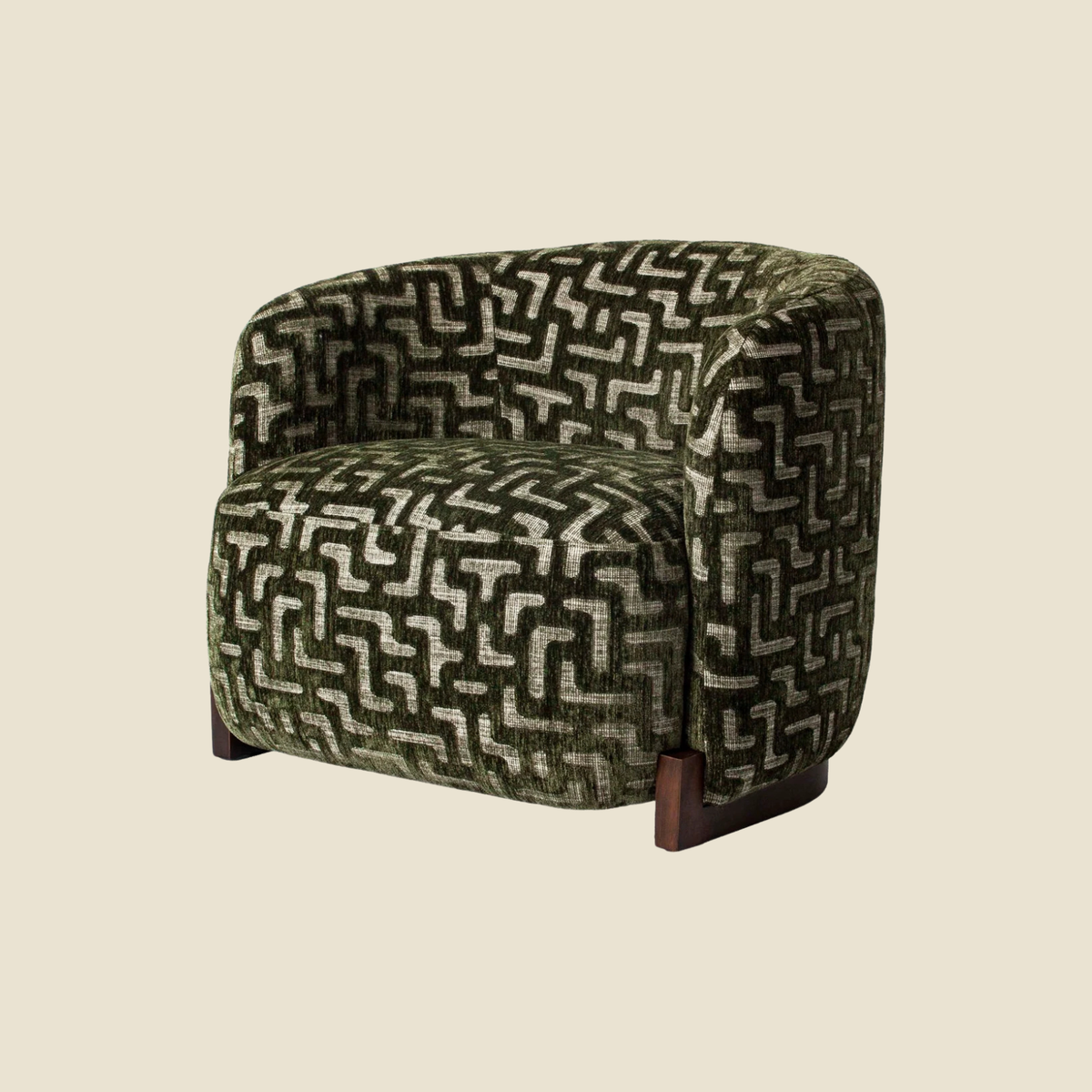 A modern barrel-style armchair upholstered in a textured geometric patterned fabric in olive green and cream, with dark wood legs, shown against a solid light beige background.