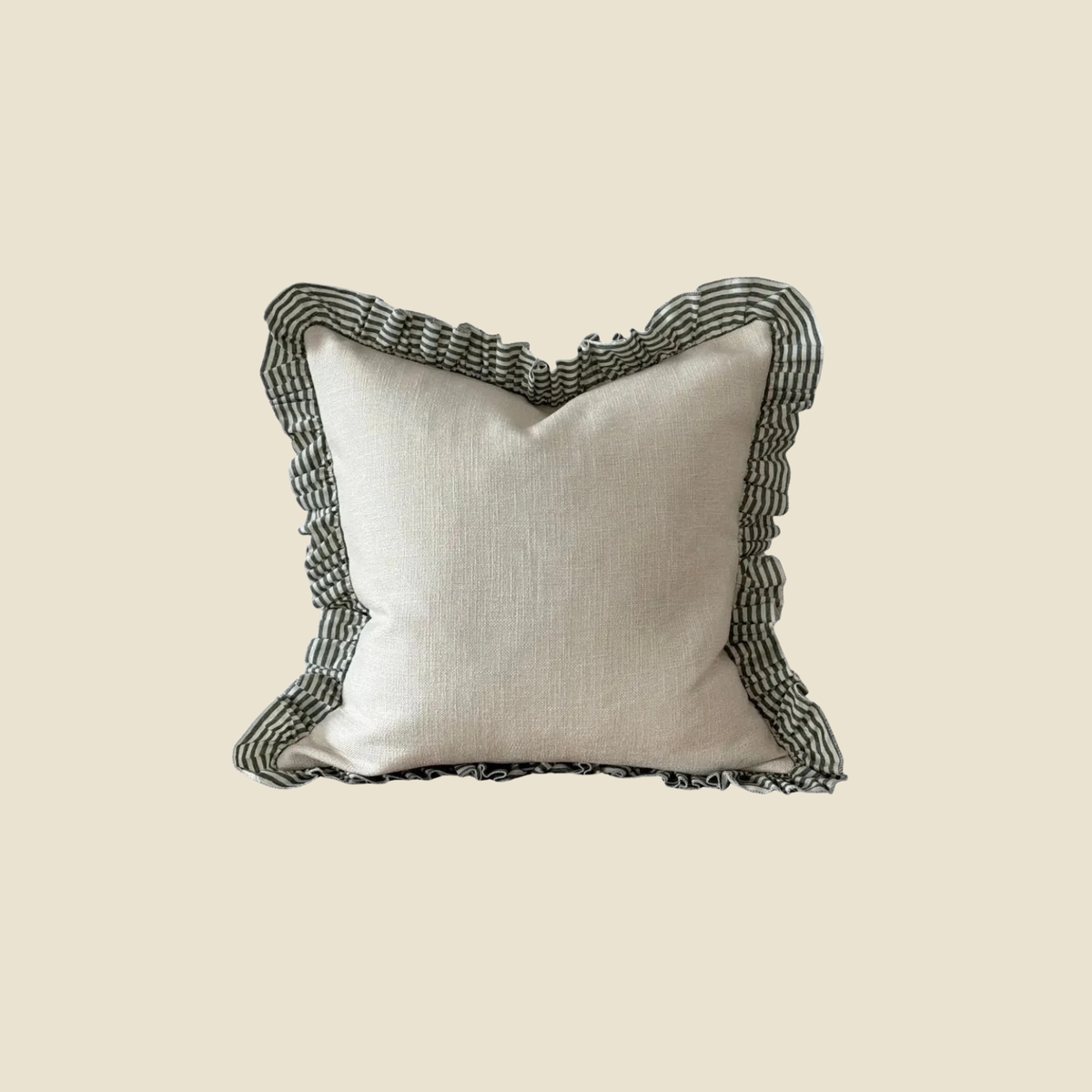 A square throw pillow with a textured off-white linen center and a dark green and white striped ruffled border, shown against a solid beige background.