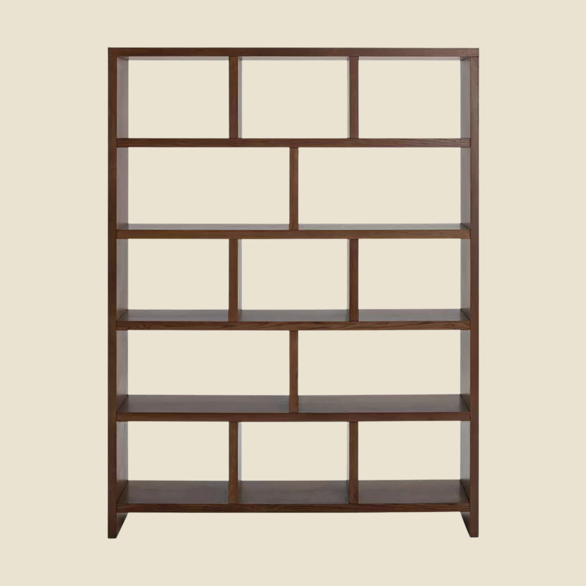 A dark brown wooden bookcase with an open grid design, featuring multiple rectangular shelves and panels, shown against a solid light beige background.
