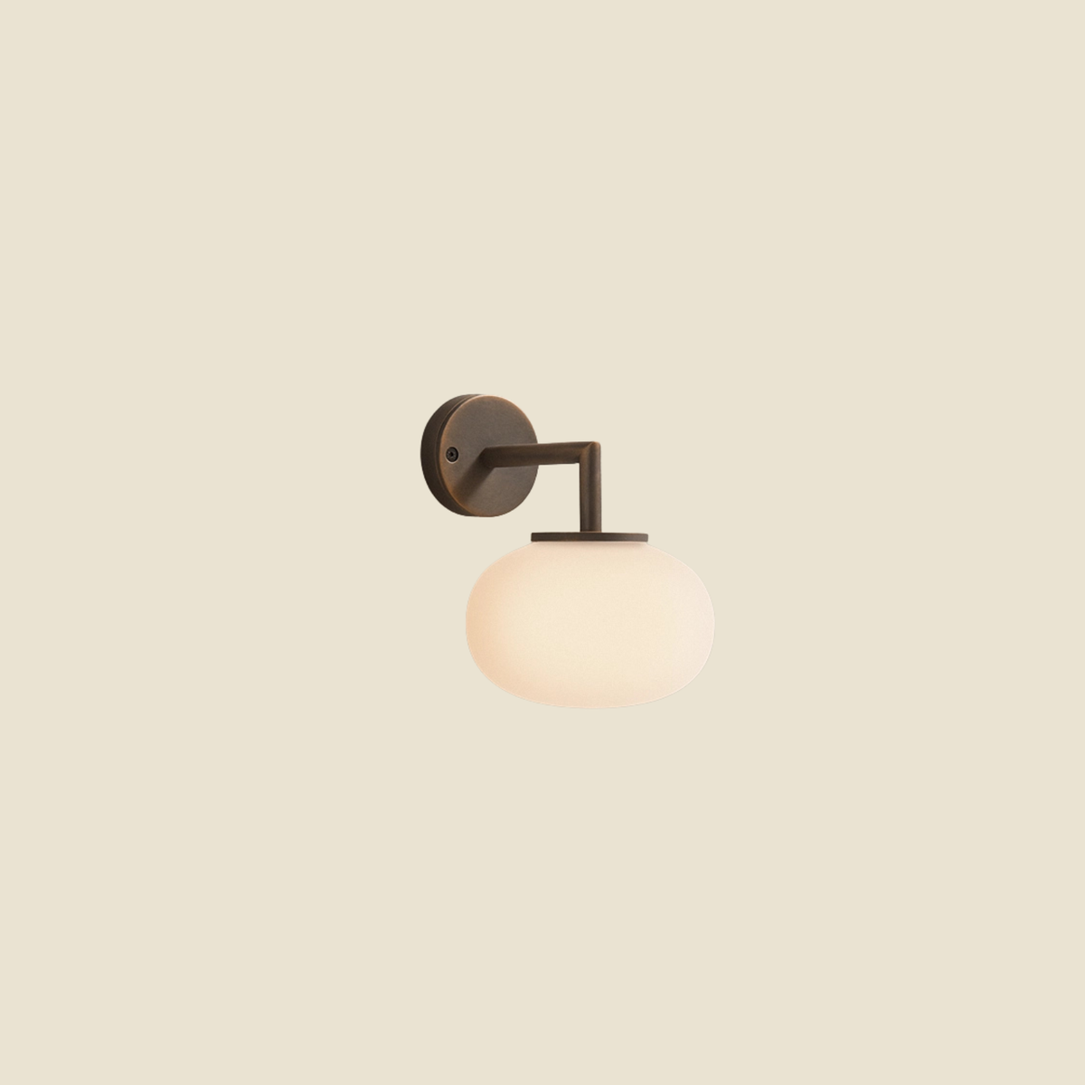 A modern wall-mounted light fixture with a dark bronze metal wall plate and curved arm, featuring a frosted white glass globe shade, shown against a solid beige background.